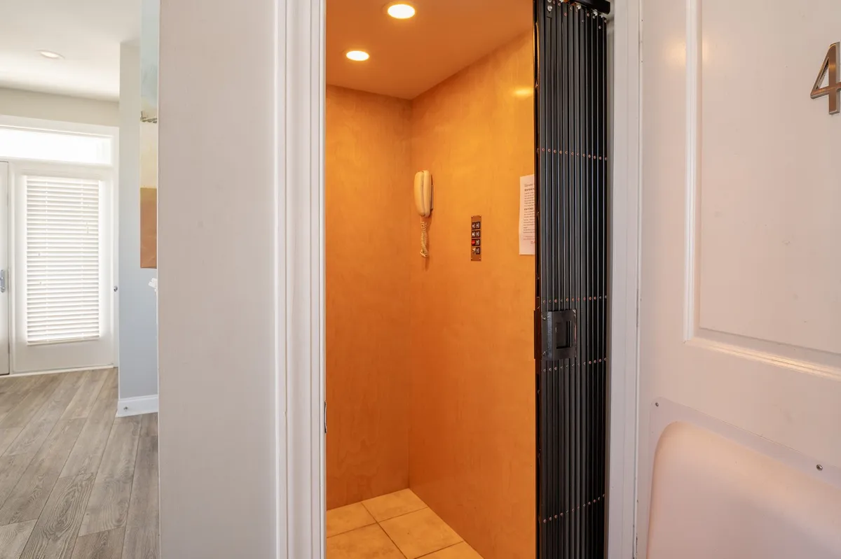 This image showcases a modern, in-unit elevator with sleek wall paneling and bright lighting fixtures. The elevator is situated conveniently within the home and the scene suggests easy access between floors for all ages.
